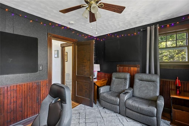 309 E Miami St, Paola, KS 66071 - home theater featuring a ceiling fan, wood walls, and wainscoting