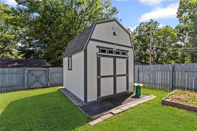 309 E Miami St, Paola, KS 66071 - view of shed featuring a fenced backyard, a garden, and a gate