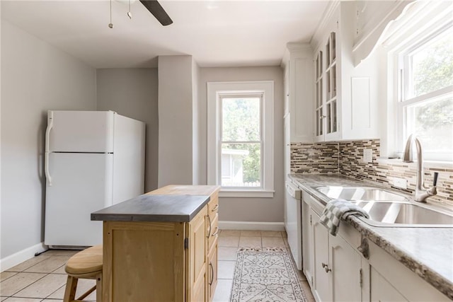521 Tracy Ave, Kansas City, MO 64016 - kitchen featuring white appliances, light tile patterned floors, glass insert cabinets, and a ceiling fan