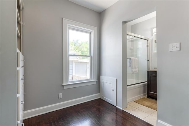 521 Tracy Ave, Kansas City, MO 64016 - bathroom with combined bath / shower with glass door and wood finished floors