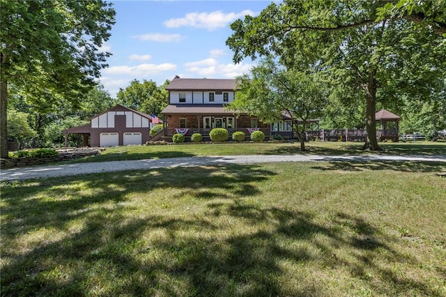 1124 S Locust St, Ottawa, KS 66067 - english style home featuring an outdoor structure, a front lawn, and a garage