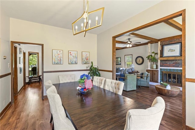 1124 S Locust St, Ottawa, KS 66067 - dining area featuring wood finished floors, a chandelier, a fireplace, beamed ceiling, and a ceiling fan