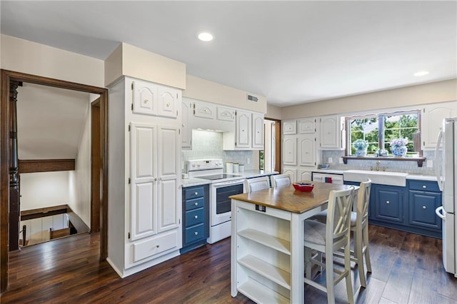 1124 S Locust St, Ottawa, KS 66067 - kitchen with white appliances, blue cabinetry, decorative backsplash, dark wood-style flooring, and wooden counters