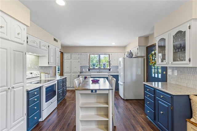 1124 S Locust St, Ottawa, KS 66067 - kitchen with white appliances, blue cabinets, backsplash, light countertops, and white cabinets