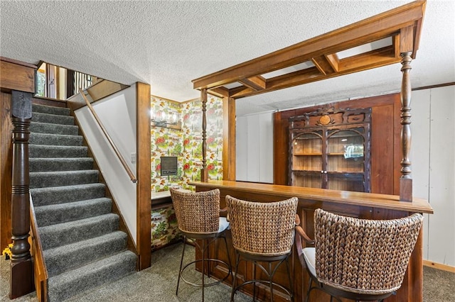 1124 S Locust St, Ottawa, KS 66067 - bar featuring carpet, stairway, and a textured ceiling