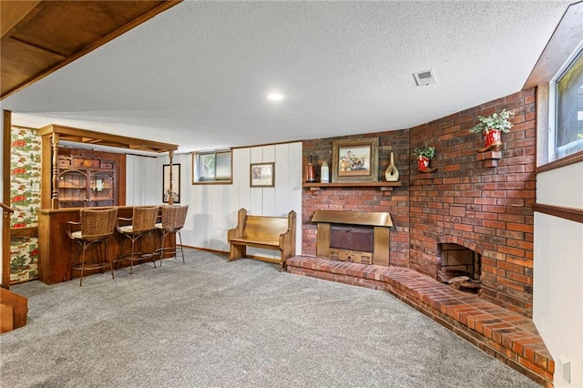 1124 S Locust St, Ottawa, KS 66067 - living room featuring a fireplace, carpet, a bar, and a textured ceiling