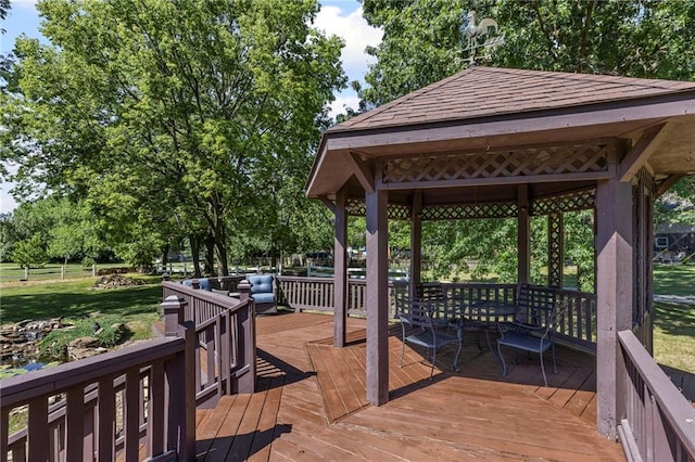 1124 S Locust St, Ottawa, KS 66067 - wooden deck featuring a gazebo, a lawn, view of scattered trees, and outdoor dining space