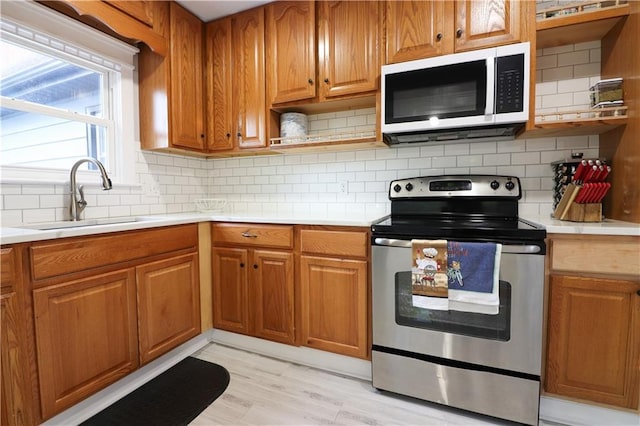 818 W 30th St, Independence, MO 64055 - kitchen featuring electric range, white microwave, open shelves, light countertops, and backsplash