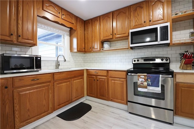 818 W 30th St, Independence, MO 64055 - kitchen featuring appliances with stainless steel finishes, open shelves, light countertops, and brown cabinets