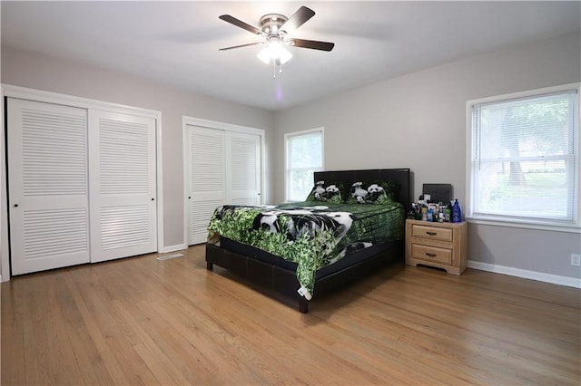 818 W 30th St, Independence, MO 64055 - bedroom with two closets, light wood-type flooring, and a ceiling fan