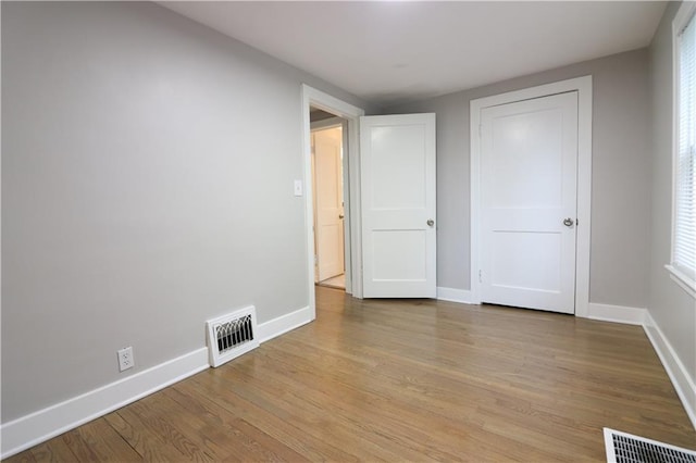 818 W 30th St, Independence, MO 64055 - unfurnished bedroom with light wood-type flooring and multiple windows