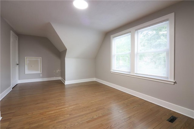 818 W 30th St, Independence, MO 64055 - additional living space featuring wood finished floors, healthy amount of natural light, and vaulted ceiling