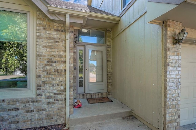 3945 N 123rd Ter, Kansas City, KS 66109 - view of exterior entry featuring brick siding, a garage, and roof with shingles