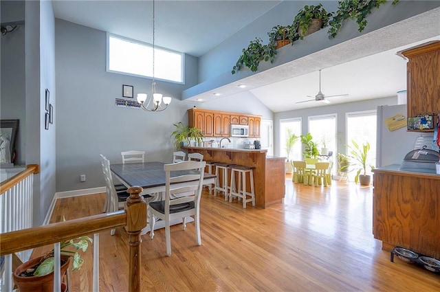 3945 N 123rd Ter, Kansas City, KS 66109 - dining room with light wood-style flooring, a chandelier, ceiling fan, and high vaulted ceiling