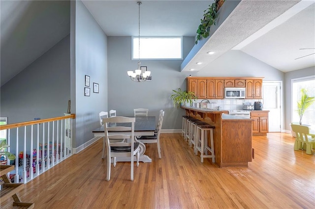 3945 N 123rd Ter, Kansas City, KS 66109 - dining area with light wood finished floors, a chandelier, and high vaulted ceiling
