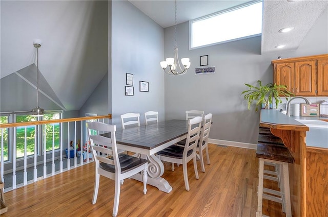 3945 N 123rd Ter, Kansas City, KS 66109 - dining room with healthy amount of natural light, a chandelier, light wood-style flooring, high vaulted ceiling, and ceiling fan
