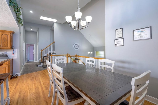 3945 N 123rd Ter, Kansas City, KS 66109 - dining space with a chandelier, light wood finished floors, vaulted ceiling, recessed lighting, and stairs