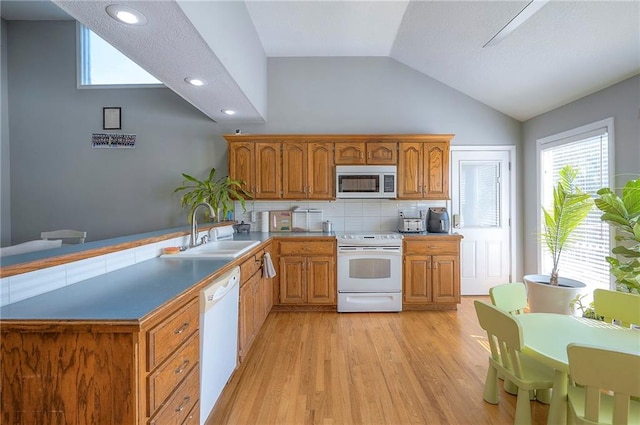 3945 N 123rd Ter, Kansas City, KS 66109 - kitchen with white appliances, lofted ceiling, light wood-type flooring, a peninsula, and brown cabinetry