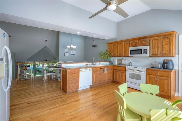 3945 N 123rd Ter, Kansas City, KS 66109 - kitchen with white appliances, ceiling fan, a peninsula, high vaulted ceiling, and a chandelier