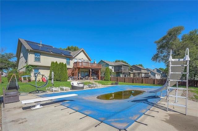 3945 N 123rd Ter, Kansas City, KS 66109 - view of pool featuring a diving board, a water slide, a wooden deck, stairway, and a residential view