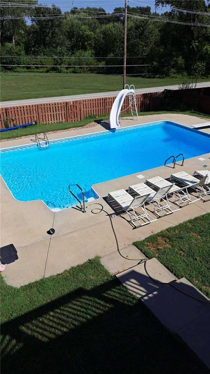 3945 N 123rd Ter, Kansas City, KS 66109 - view of pool featuring a water slide, a fenced backyard, and a diving board