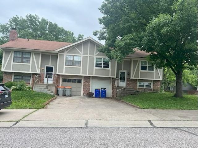 10195 Haskins St, Lenexa, KS 66217 - split foyer home featuring brick siding, concrete driveway, a garage, a chimney, and stucco siding