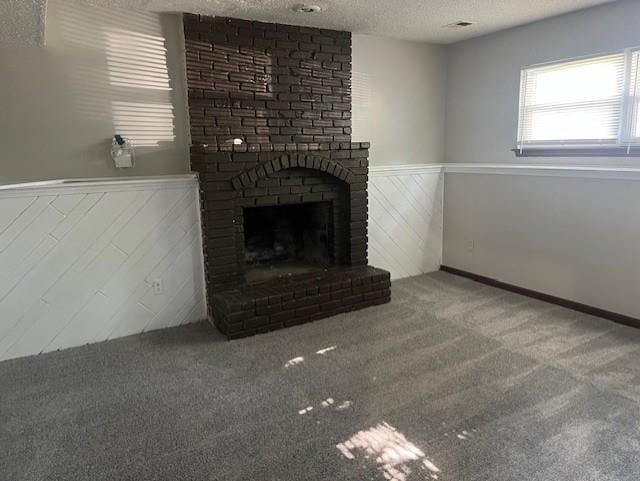 10195 Haskins St, Lenexa, KS 66217 - unfurnished living room with a wainscoted wall, a textured ceiling, a fireplace, and carpet flooring