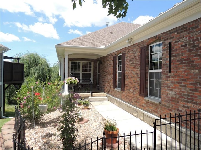 3722 S Bolger Ct, Independence, MO 64055 - doorway to property featuring brick siding and roof with shingles