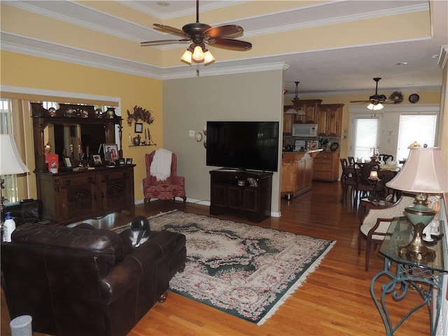 3722 S Bolger Ct, Independence, MO 64055 - living area featuring a ceiling fan, wood finished floors, ornamental molding, and a raised ceiling