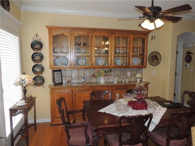 3722 S Bolger Ct, Independence, MO 64055 - dining area with arched walkways, ceiling fan, light wood-type flooring, and crown molding