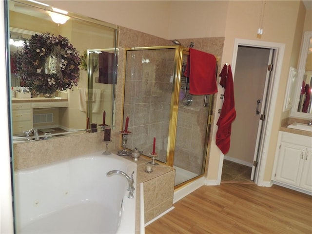 3722 S Bolger Ct, Independence, MO 64055 - bathroom featuring a stall shower, a tub with jets, vanity, and wood finished floors