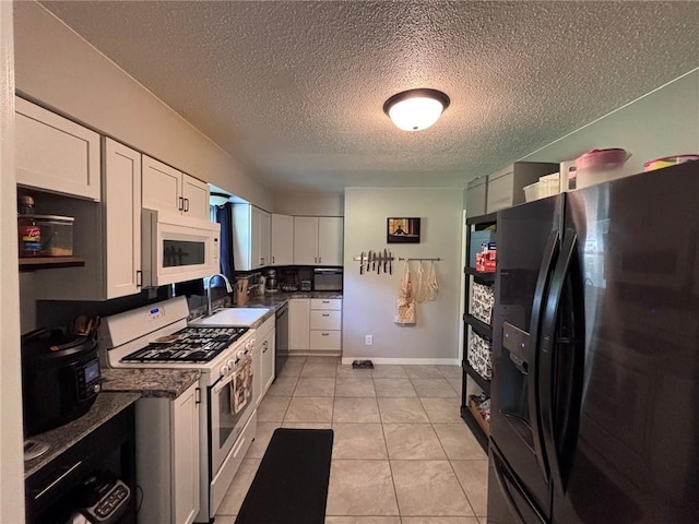3335 N 54th St, Kansas City, KS 66104 - kitchen with black appliances, white cabinets, a textured ceiling, dark countertops, and light tile patterned floors