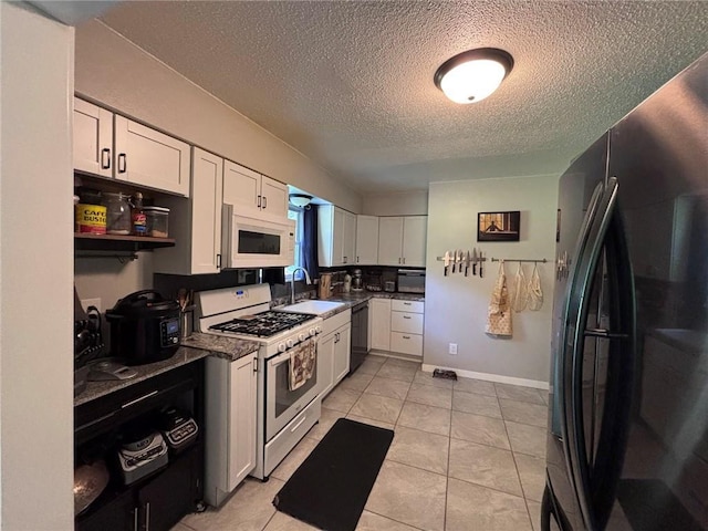 3335 N 54th St, Kansas City, KS 66104 - kitchen featuring white appliances, a textured ceiling, white cabinets, light tile patterned floors, and open shelves