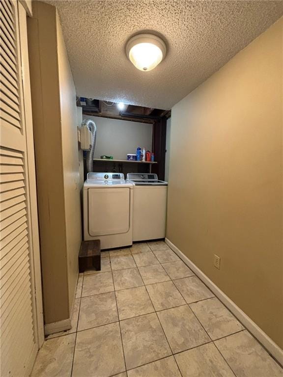2425 Elephant Trl, Saint Joseph, MO 64506 - laundry area with washing machine and clothes dryer, a textured ceiling, and light tile patterned floors