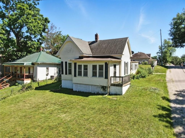 216 Dunbar Ave, Excelsior Springs, MO 64024 - rear view of house with a lawn, roof with shingles, and a chimney