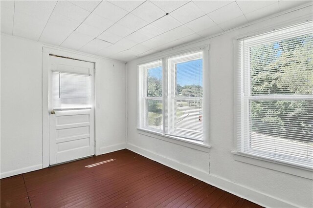 216 Dunbar Ave, Excelsior Springs, MO 64024 - unfurnished room with dark wood finished floors and plenty of natural light