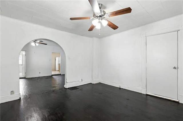 216 Dunbar Ave, Excelsior Springs, MO 64024 - empty room with arched walkways, ceiling fan, and dark wood finished floors