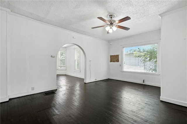216 Dunbar Ave, Excelsior Springs, MO 64024 - empty room featuring plenty of natural light, arched walkways, a textured ceiling, dark wood finished floors, and ceiling fan