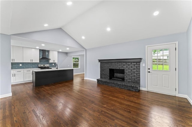 9916 Floyd St, Overland Park, KS 66212 - living room featuring plenty of natural light, a fireplace, lofted ceiling, dark wood finished floors, and recessed lighting