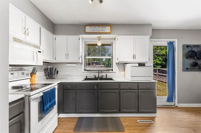 800 S Park Ave, Oak Grove, MO 64075 - kitchen featuring white appliances, white cabinetry, light countertops, and light wood finished floors