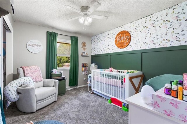 800 S Park Ave, Oak Grove, MO 64075 - carpeted bedroom featuring a nursery area, a textured ceiling, and a ceiling fan