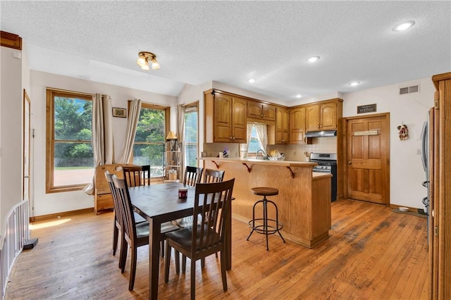 2431 S Ponca Ave, Independence, MO 64057 - dining space with a textured ceiling, plenty of natural light, light wood-style flooring, and recessed lighting