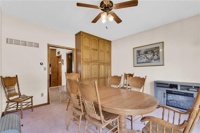 2431 S Ponca Ave, Independence, MO 64057 - dining space with ceiling fan, light carpet, and a glass covered fireplace