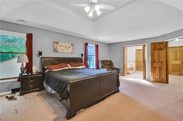 2431 S Ponca Ave, Independence, MO 64057 - bedroom with carpet floors, connected bathroom, a ceiling fan, and a raised ceiling
