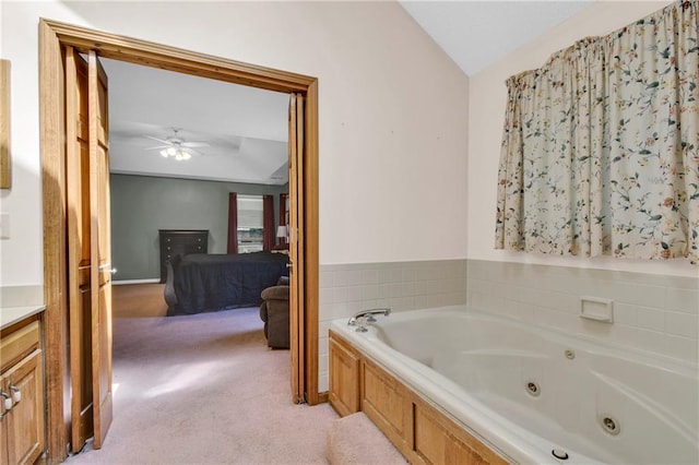 2431 S Ponca Ave, Independence, MO 64057 - bathroom featuring a tub with jets, vaulted ceiling, a ceiling fan, ensuite bathroom, and vanity