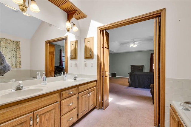 2431 S Ponca Ave, Independence, MO 64057 - ensuite bathroom with double vanity, lofted ceiling, ceiling fan, and a tub to relax in