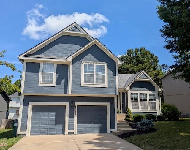 22030 W 51st Ter, Shawnee, KS 66226 - view of front of property with driveway, an attached garage, and a front lawn