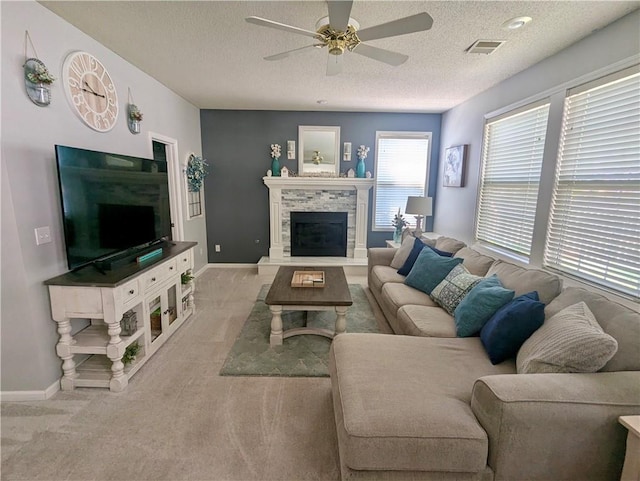 22030 W 51st Ter, Shawnee, KS 66226 - carpeted living room featuring a ceiling fan, a textured ceiling, and a fireplace with raised hearth