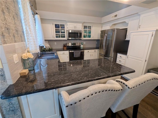 22030 W 51st Ter, Shawnee, KS 66226 - kitchen featuring appliances with stainless steel finishes, a peninsula, glass insert cabinets, and tasteful backsplash