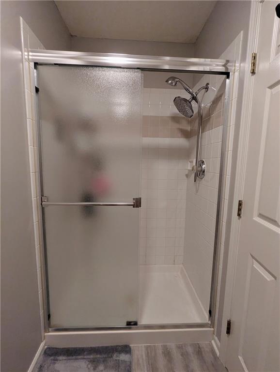 22030 W 51st Ter, Shawnee, KS 66226 - bathroom with a stall shower and wood finished floors